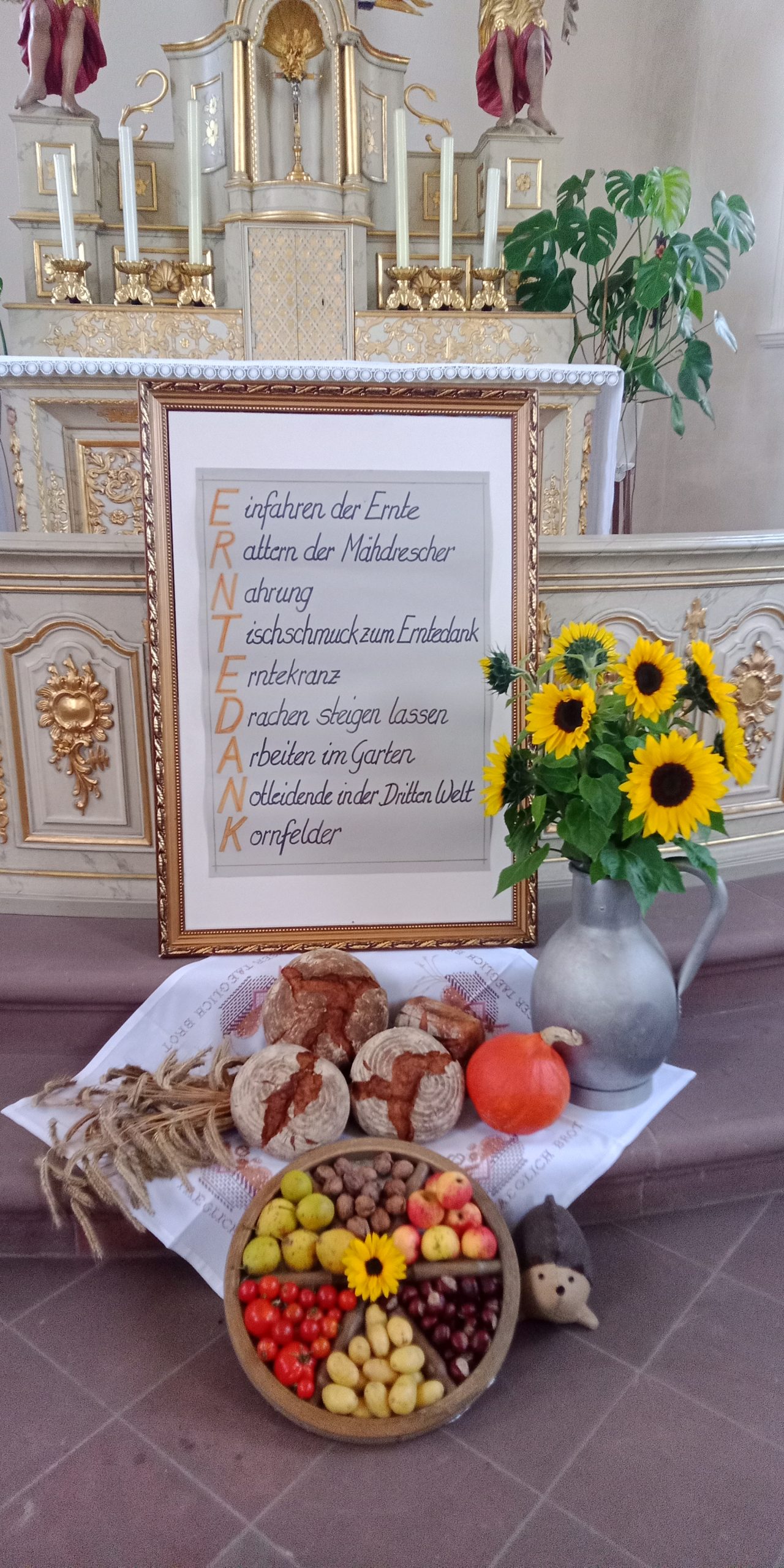Erntegaben und Sonnenblumen im Altarraum einer Kirche